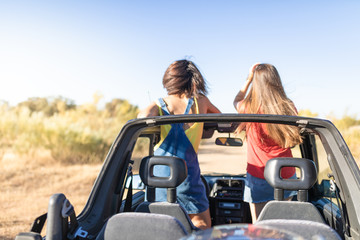 beautiful girls and young people traveling with the jeep car