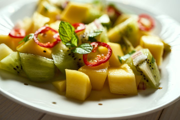 Fresh organic colorful salad with melon on white wooden table