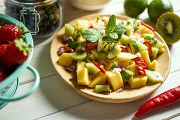 Fresh organic colorful salad of melon with chili on white table