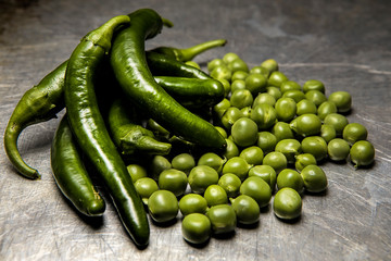Studio photo of peppers and peas.
