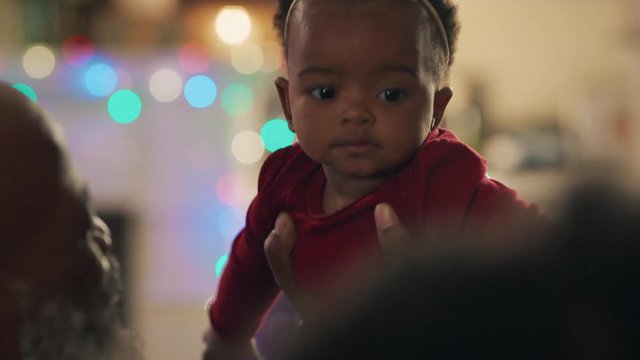 african american family christmas grandfather holding baby girl giving kiss proud of granddaughter happy grandparents enjoying festive holiday reunion at home 4k