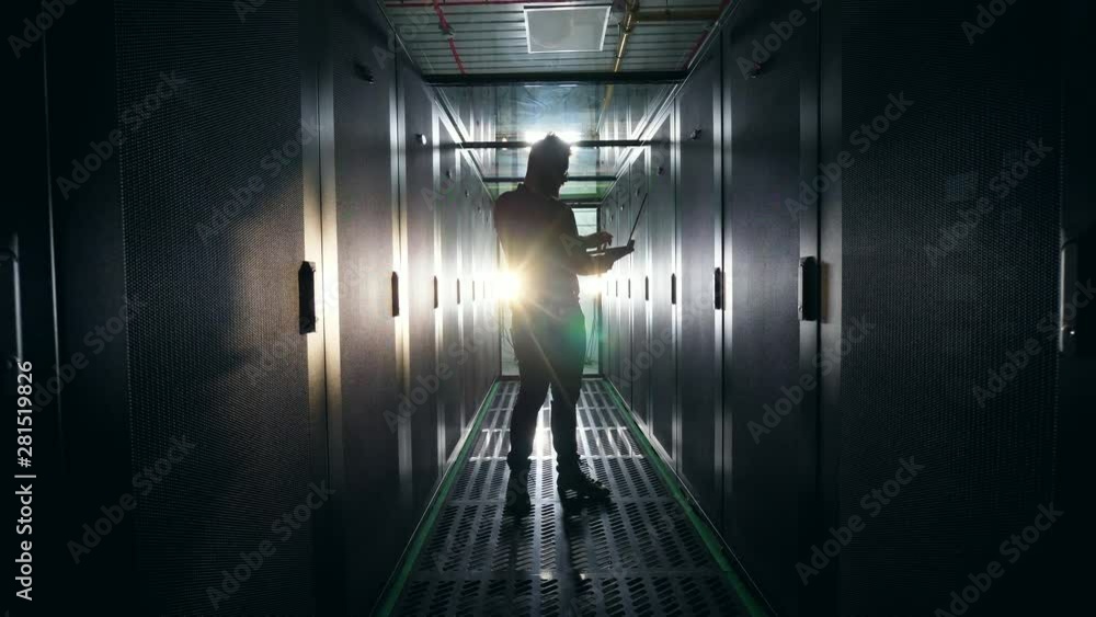 Aufkleber server room with a backlit silhouette of a male technician. server engineer working at data center