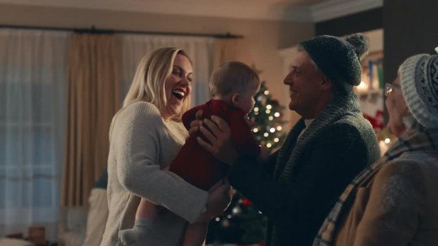 grandparents visiting for christmas eve hugging family and baby enjoying festive celebration reunion at home 4k footage