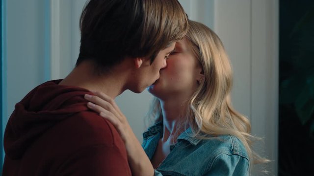 happy teenage couple first kiss girl kissing boyfriend at home after romantic evening date together 4k