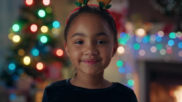 portrait cute african american girl celebrating christmas wearing funny reindeer antlers enjoying festive holiday with colorful lights having fun evening at home 4k footage 