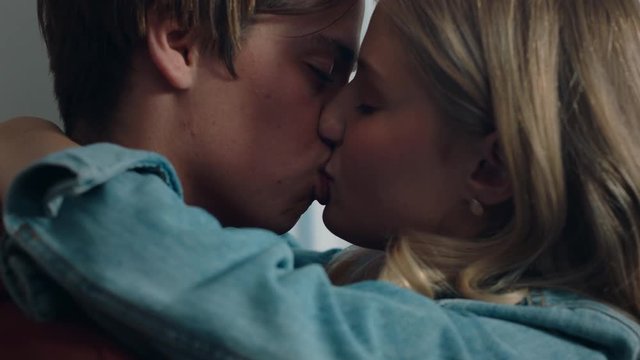 happy teenage couple first kiss girl kissing boyfriend at home after romantic evening date together 4k