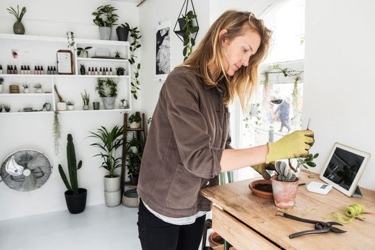 Side view of woman working in plant shop