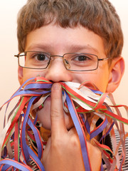 Portrait of a boy with a mustache of serpentine. Christmas mood.