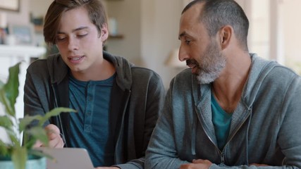 father and son using laptop computer dad helping teenage boy with homework at home teaching problem solving parent supporting education 4k - Powered by Adobe