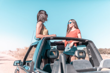 Naklejka premium beautiful girls and young people traveling with the jeep car