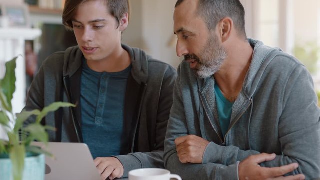 father and son high five using laptop computer dad helping teenage boy with homework successful problem solving 4k