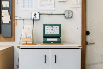 Time clock on wooden table in workshop