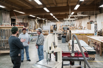 Carpenters talking with each other in workshop