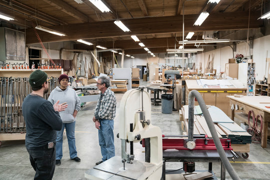 Carpenters talking with each other in workshop