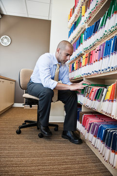 Dentist looking through file folders in office