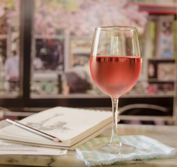 Glass of wine in a cafe at a table with a sketch pad and pencil
