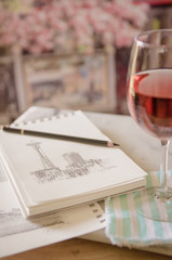 Glass of wine with a sketch pad and pencil on a marble table