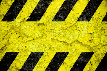 Warning danger sign yellow and black stripes pattern with yellow area over concrete cement wall...