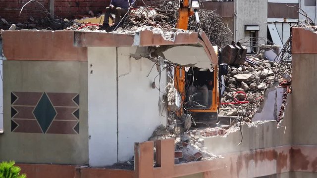 Building Demolition is a stock video that shows fine footage of Building demolition procedure, high reach excavator eliminating old construction. 
