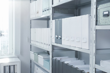 Folders with documents on shelves in archive