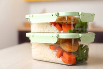 Boxes with prepared meals on table against blurred background