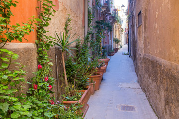 Fototapeta na wymiar The beautiful narrow streets of Ortigia, Syracuse historical centre, with typical buildings facades