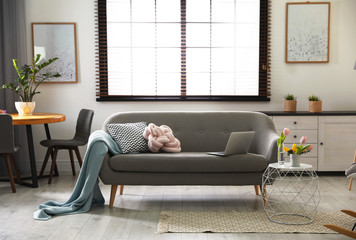Interior of cozy living room with grey sofa