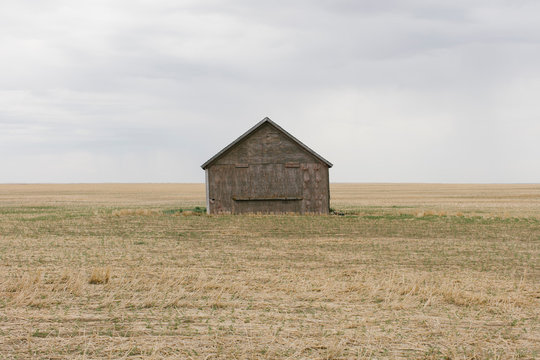 View of old barn in fallow field