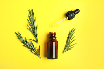 Flat lay composition with rosemary essential oil on yellow background