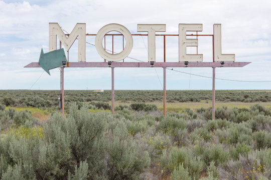 View of motel sign in field of sage bush