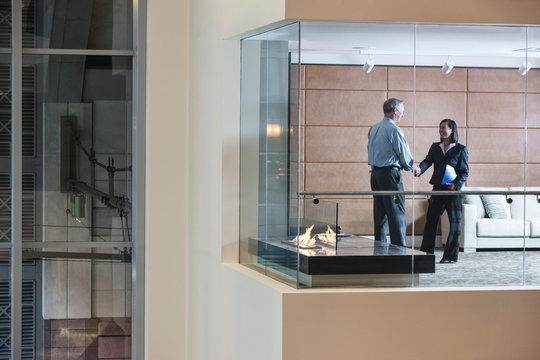 Business people shaking hands in office lobby
