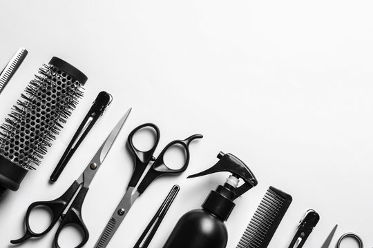 Composition with scissors and other hairdresser's accessories on white background, top view