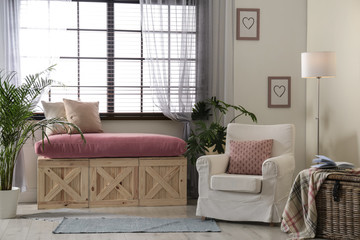Elegant living room interior with comfortable armchair near window