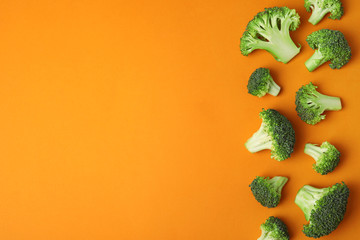Flat lay composition with fresh green broccoli on color background. Space for text