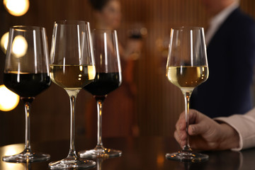 Woman with glass of wine in restaurant, closeup