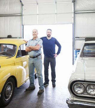 Portrait of mechanic with his son standing in automobile repair shop
