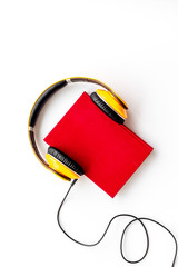 listen to audio books with headphone on white background flatlay