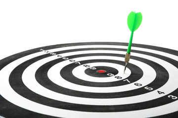 Dart board with color arrow hitting target, closeup
