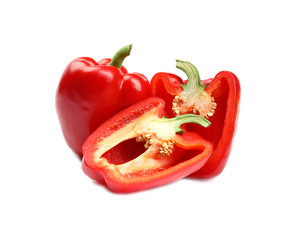 Whole and cut red bell peppers on white background