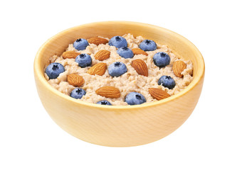 Homemade  oatmeal porridge with blueberries and almond  in wooden bowl isolated.   Healthy eating, healthy breakfast food.