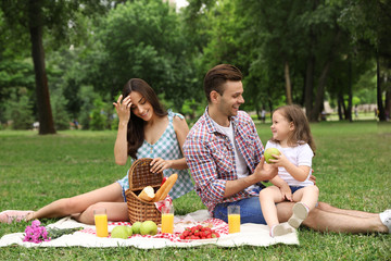 Happy family having picnic in park on summer day