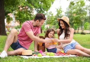 Fototapeta premium Happy family having picnic in park on summer day