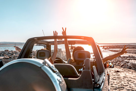 beautiful girls and young people traveling with the jeep car