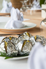 Baked potatoes in foil served on the restaurant table