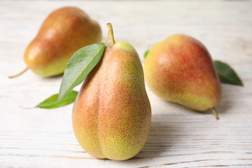 Ripe juicy pears on white wooden table