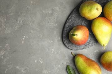 Ripe juicy pears on grey stone table, flat lay. Space for text