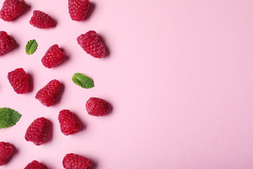 Flat lay composition with delicious ripe raspberries on pink background. Space for text