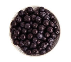 Ceramic plate with fresh acai berries on white background, top view