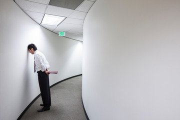 Frustrated businessman standing in office corridor