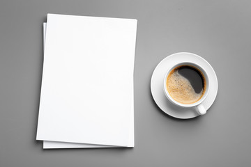 Obraz na płótnie Canvas Blank paper sheets for brochure and cup of coffee on grey background, flat lay. Mock up